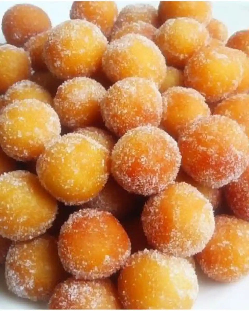 sugar-coated-mini-donuts A pile of golden brown mini donuts covered in sugar crystals