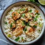 Plate of Coconut Chicken served with rice and garnished with herbs