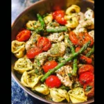 One-pan pesto chicken with tortellini and colorful veggies ready to serve.